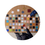 Overhead view of people selecting material and color samples at wood table